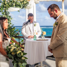 A couple stands together with the minister who married them on the scenic rooftop of La Sirena Puerto Morelos, home of Let's Marry in Mexico.