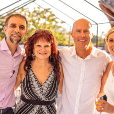 The bride and groom stand on the rooftop with Anthony of La Sirena and one of their guests of honor.