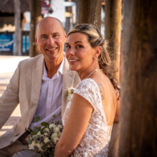 A newly married couple pauses for wedding photos in the park along the beach in Puerto Morelos.