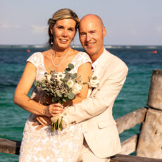 A newly married couple embraces for wedding photos at the pier in Puerto Morelos.