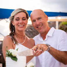 Newlyweds cutting their wedding cake during their wedding reception on the rooftop at La Sirena Puerto Morelos.