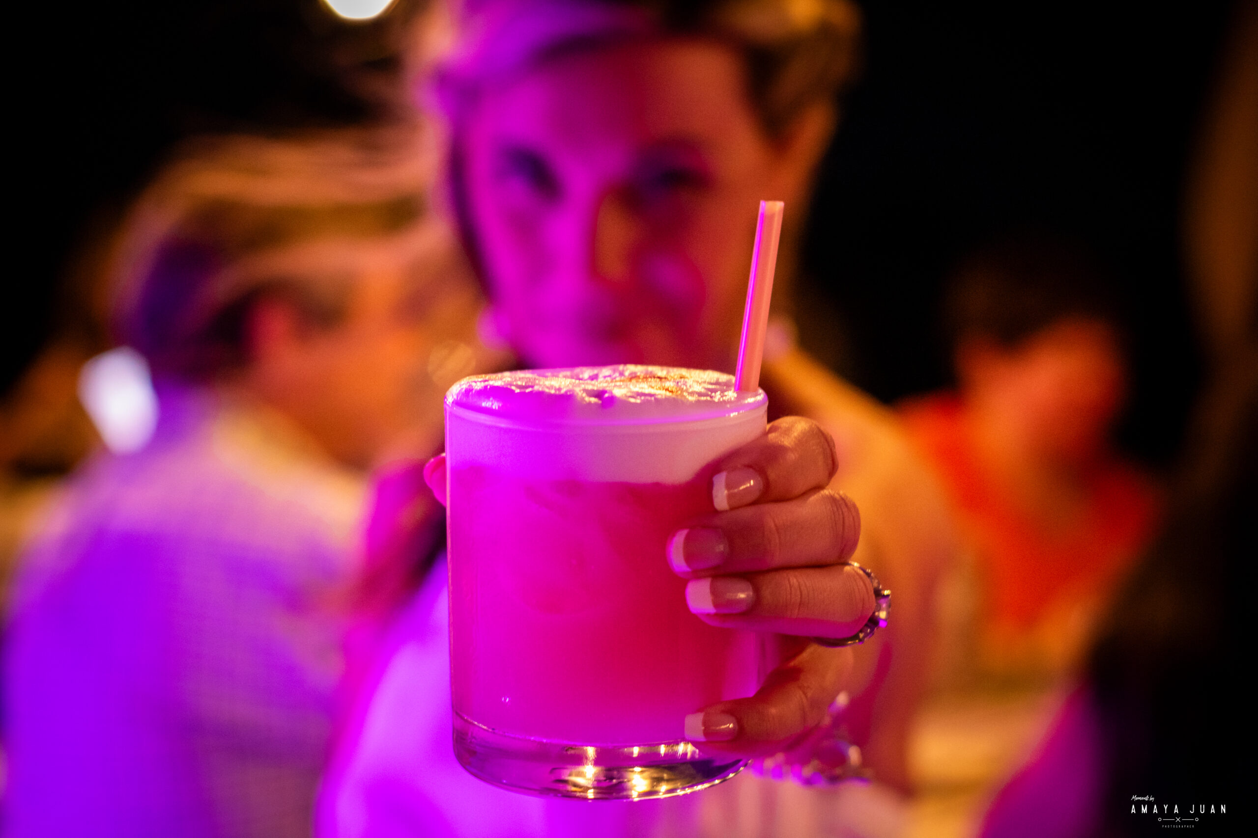 The bride holds out her cocktail towards the camera on the rooftop at La Sirena Puerto Morelos.