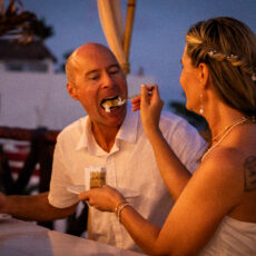 The bride feeds the groom a piece of wedding cake on the rooftop at La Sirena Puerto Morelos.