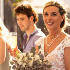 The bride holding her wedding bouquet and enjoying champaign on the rooftop at La Sirena Puerto Morelos.