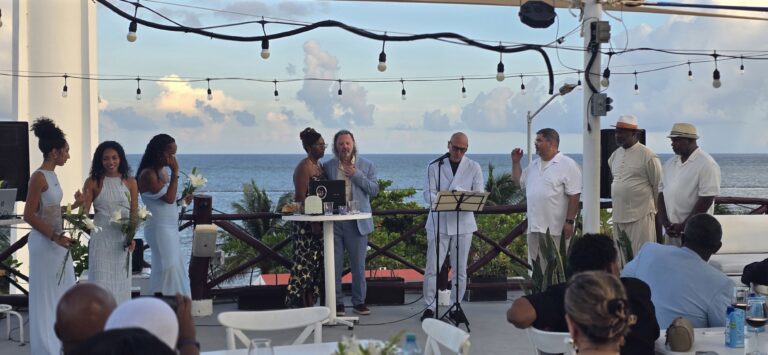 Destination wedding ceremony on a rooftop in Puerto Morelos with the wedding party and ocean view